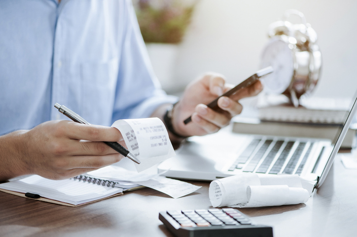 joven sosteniendo un bolígrafo con facturas trabajando para calcular datos comerciales, impuestos, pago de facturas, comenzar a contar finanzas. concepto de contabilidad, estadística e investigación analítica